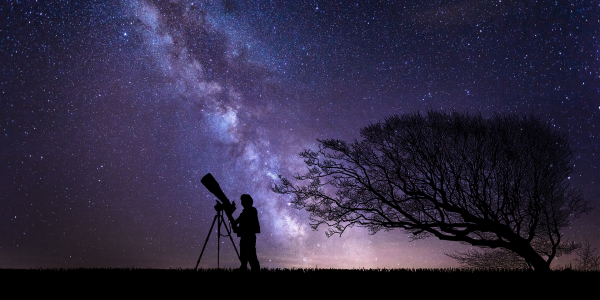 A telescope and an astronomer viewing the Milky Way, Pixabay image.