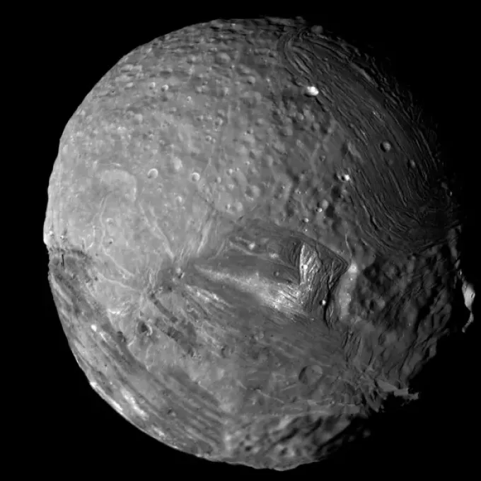 Unique geologic features on Uranus’ moon Miranda (seen here in a photo taken by Voyager 2 in 1986) may have been created by thinning of the moon’s icy shell.  Kevin M. Gill/JPL/NASA